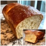A close-up of a freshly baked loaf of Irresistible Copycat Cheesecake Factory Honey Wheat Bread, with a slice cut to show its soft, airy crumb.
