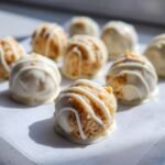 Close-up of irresistible easy carrot cake truffles drizzled with white chocolate.