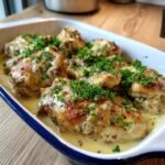 A baking dish filled with Easy Gluten Free Dinner: Delicious Chicken Delight, coated in a creamy sauce and garnished with parsley.