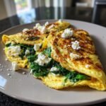 A delicious Energizing High Protein Breakfast omelette filled with spinach and topped with crumbled feta cheese.