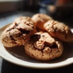 Close-up of Irresistible Button Cookies with chocolate chips, on a white plate.