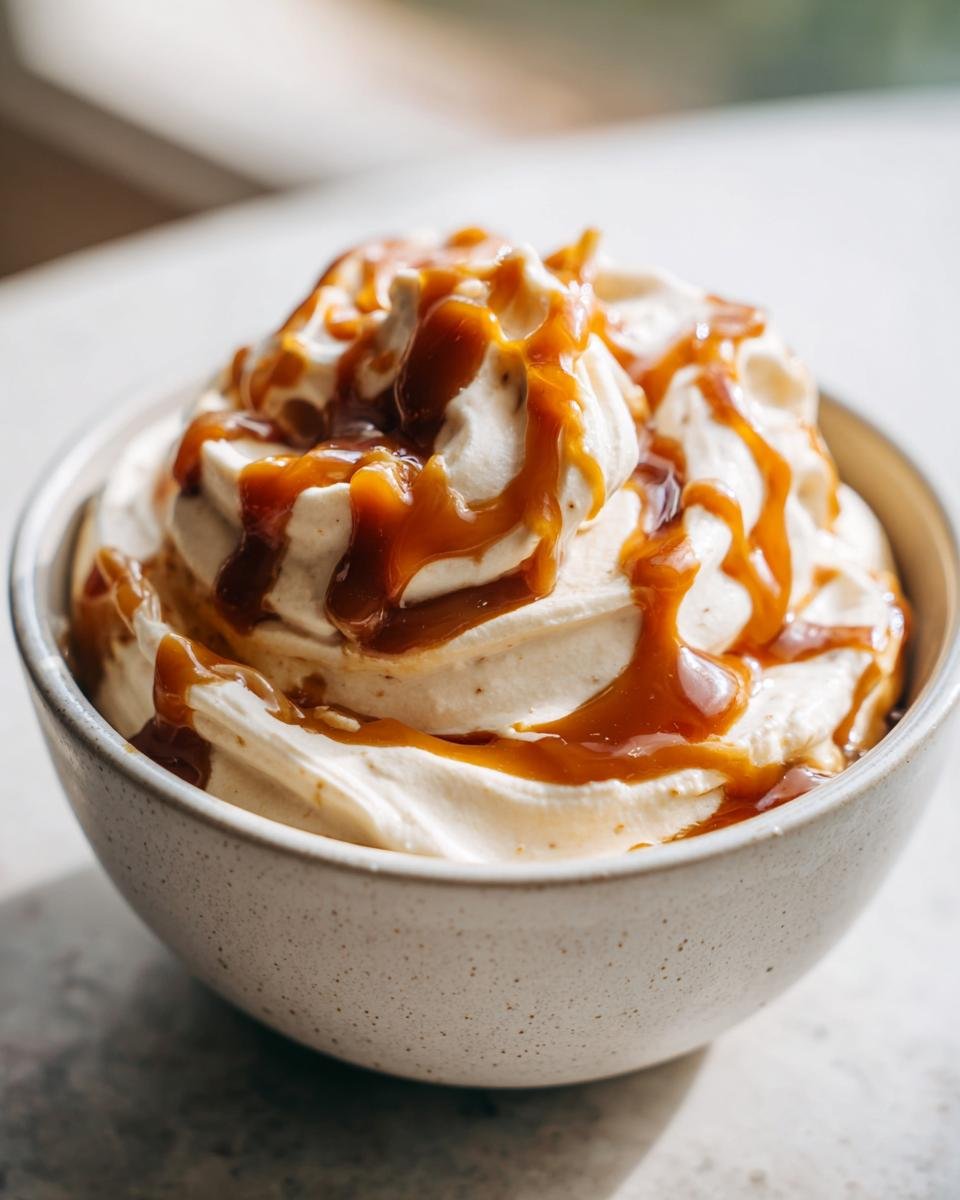 Close-up of a bowl filled with Irresistible Easy Caramel Pumpkin Pie Cheesecake Dip, generously drizzled with caramel sauce.