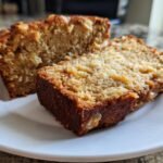 Two slices of Irresistible Hawaiian Banana Bread on a white plate, showcasing its moist texture and banana chunks.