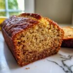 A close-up of a slice of irresistible healthy banana bread, showcasing its moist crumb and golden-brown crust.