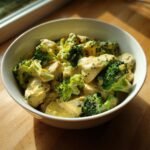 A bowl of Irresistible Slow Cooker Chicken and Broccoli in a creamy sauce.