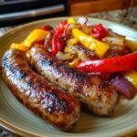 Two grilled Andouille sausages served with colorful saut&eacute;ed peppers and onions on a plate.