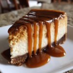 A decadent slice of Caramel Pumpkin Spice Cheesecake topped with thick, dripping caramel sauce.