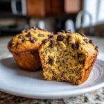 Close-up of a Chocolate Chip Chia Seed Energy Muffin, with one muffin cut in half to show the texture and chia seeds.