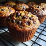 Close-up of an Irresistible Banana Muffin With Chocolate Chips on a cooling rack.