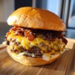 Close-up of an irresistible smash burger with melted cheese and crispy bacon on a bun.