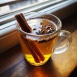 Close-up of a Maple Chai Hot Toddy Mocktail garnished with cinnamon sticks and star anise.