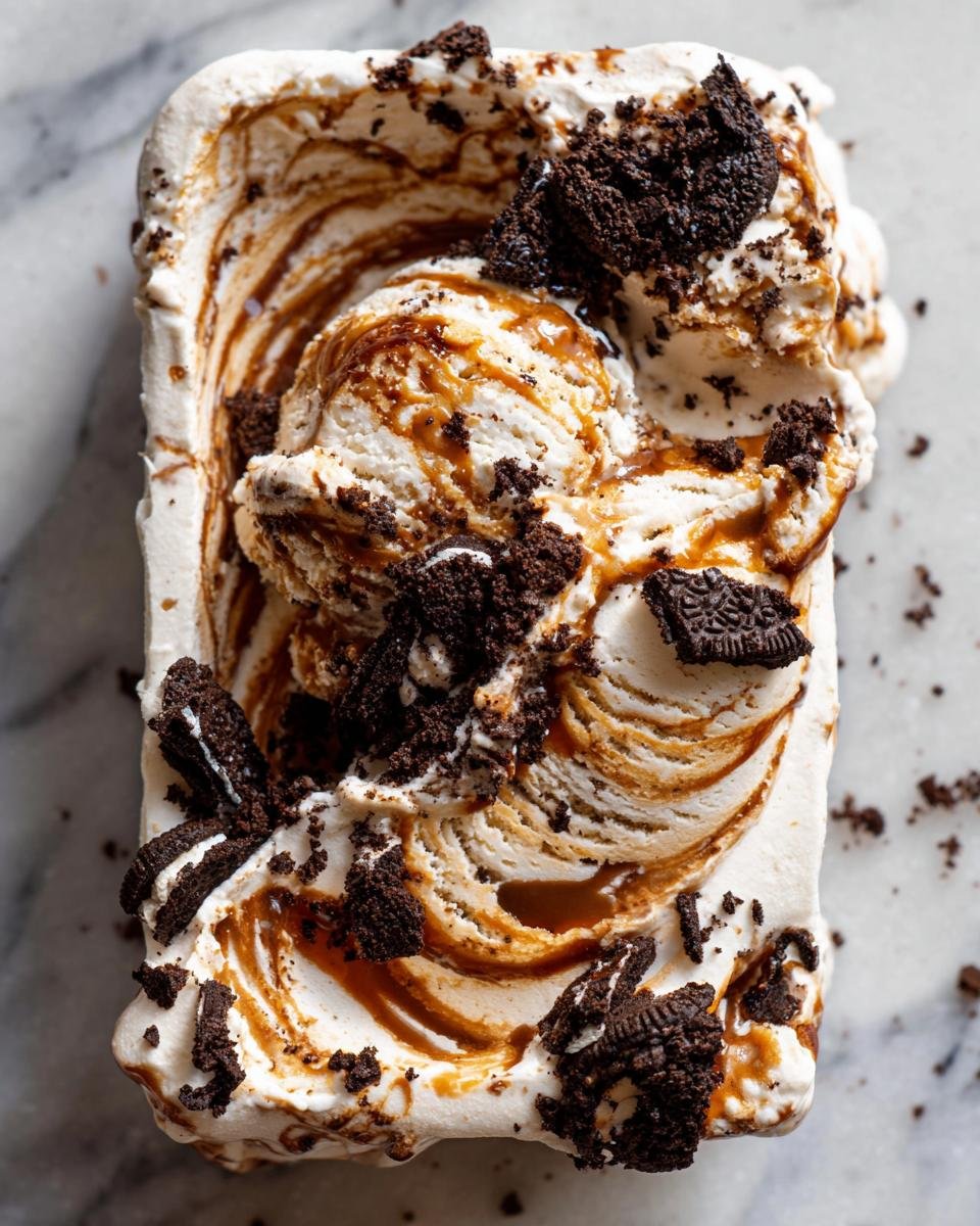 Overhead view of homemade No Churn Salted Caramel Oreo Ice Cream swirled with caramel and topped with crushed cookies.