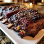 Close-up of tender, juicy Ultimate Smoked Beef Ribs with a dark, flavorful bark.