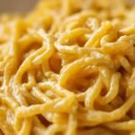 Extreme close-up showing the stringy texture coated in a rich, creamy sauce of Creamy Spaghetti Squash.