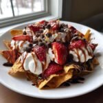 Plate of Dessert Nachos With Cinnamon Sugar Tortilla Chips topped with whipped cream, strawberries, and chocolate chips.