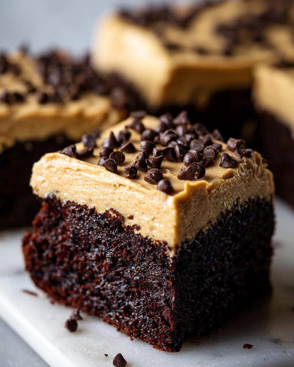 Close-up of a rich, dark Fudge Brownies With Baileys Buttercream Frosting slice topped with mini chocolate chips.
