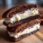 Two halves of Gingerbread Whoopie Pies stacked, showing the dark brown cake and thick vanilla buttercream filling.