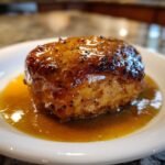 A close-up of a perfectly cooked chicken thigh coated in a thick, glossy Honey Beer Sauce.