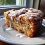 Close-up of a slice of Irresistible Amish Apple Fritter Bread drizzled with white glaze.