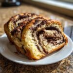 Two thick slices of an Irresistible Chocolate Babka Recipe showing rich, swirled chocolate filling and golden crust.