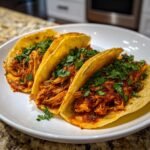 Three golden, crispy tacos filled with rich, shredded Meatless Birria Tacos With Jackfruit and topped with fresh cilantro.