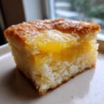 Close-up of a square slice of Taiwanese Pineapple Cake showing a thick, jammy pineapple filling over a light cake base.