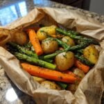 Roasted spring vegetables and potatoes in parchment paper, featuring carrots, asparagus, and baby potatoes.