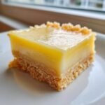 Close-up of one Irresistibly Creamy Vanilla Custard Square with a thick yellow top layer and crumbly base.