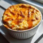 Close-up of an individual serving of Irresistible Buffalo Chicken Dip, baked until golden and bubbly.