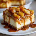 A close-up of an Irresistible Caramel Apple Cheesecake Bars slice topped with chunky caramelized apples and sauce.