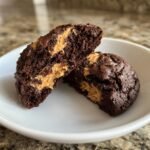 A cross-section of an Irresistible Chocolate Peanut Butter Swirl Cookie showing the rich, fudgy chocolate exterior and creamy peanut butter swirl filling.