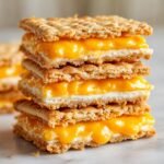 Close-up of a stack of three Irresistible Copycat Ritz Cheese Cracker Sandwiches with gooey melted cheese filling.