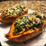 Two halves of baked sweet potatoes filled with creamy mushroom and spinach stuffing and topped with melted cheese, showcasing the Irresistible Creamy Mushroom And Spinach Stuffed Sweet Potatoes.