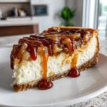 A decadent slice of Irresistible Salted Caramel Apple Pie Cheesecake topped with thick caramel sauce.