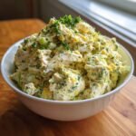 A white bowl filled high with a creamy, chunky Refreshing Crab Salad Recipe For Summer Picnics, garnished with fresh parsley.