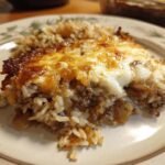 A close-up serving of Savory French Onion Beef Rice Casserole Recipe Delight with melted, browned cheese topping.