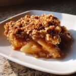 Close-up of a serving of Sheet Pan Maple Roasted Pear Crisp with a thick oat topping.