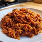 A close-up of a hearty serving of Irresistible Sloppy Joe Style Orzo on a white plate.