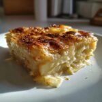 A close-up slice of Creamy Potato Leek Au Gratin Recipe with a golden-brown, bubbly top.