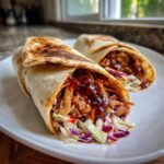 Two Flavorful BBQ Chicken Coleslaw Wraps filled with shredded chicken and colorful slaw, served on a white plate.
