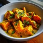 Close-up of vibrant orange chunks in a creamy yellow sauce, garnished with fresh cilantro, showcasing the Indian Pumpkin Curry Recipe.
