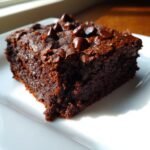 A rich, fudgy square of Indulgent Sweet Potato Brownies Healthy Dessert Delight topped with chocolate chips.