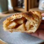 Close-up of a flaky pastry cross-section revealing warm, spiced apple filling from the Irresistible Apple Galette Recipe.