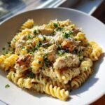 A close-up of Irresistible Chicken Caesar Pasta Salad Recipe Delight featuring rotini pasta, creamy sauce, chicken pieces, and parsley.