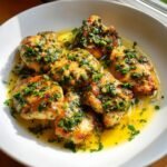 Close-up of Irresistible Chicken Scallopini pieces topped with fresh parsley and capers in a bright lemon butter sauce.