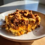 A close-up of a hearty serving of Irresistible Chorizo Dressing Casserole with a golden, crumbly topping.