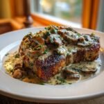 A perfectly seared pork chop smothered in a rich, creamy mushroom sauce, part of the Irresistible Cream Of Mushroom Pork Chops Recipe.