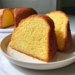 Two thick slices of moist, golden Irresistible French Butter Cake served on a light plate.