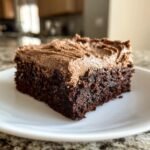 A close-up of a rich, dark chocolate slice topped with thick coffee frosting, part of the Irresistible Frosted Coffee Brownies Recipe.