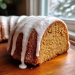 Close-up of a slice of Irresistible Holiday Spice Bundt Cake featuring a thick, white glaze dripping down the sides.